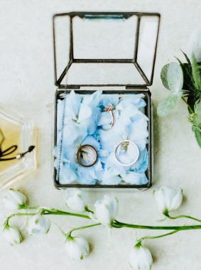 wedding ring and flowers with perfume lay flat. Wedding bridal accessories.